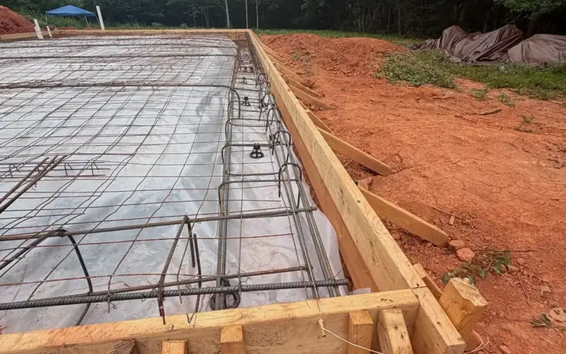 Tied rebar footing cage over vapor barrier in wood forms